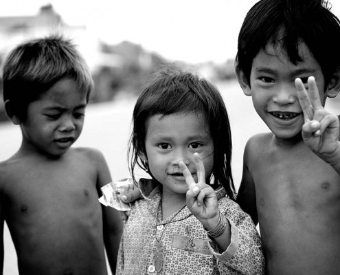 Young children making the peace sign with their hands