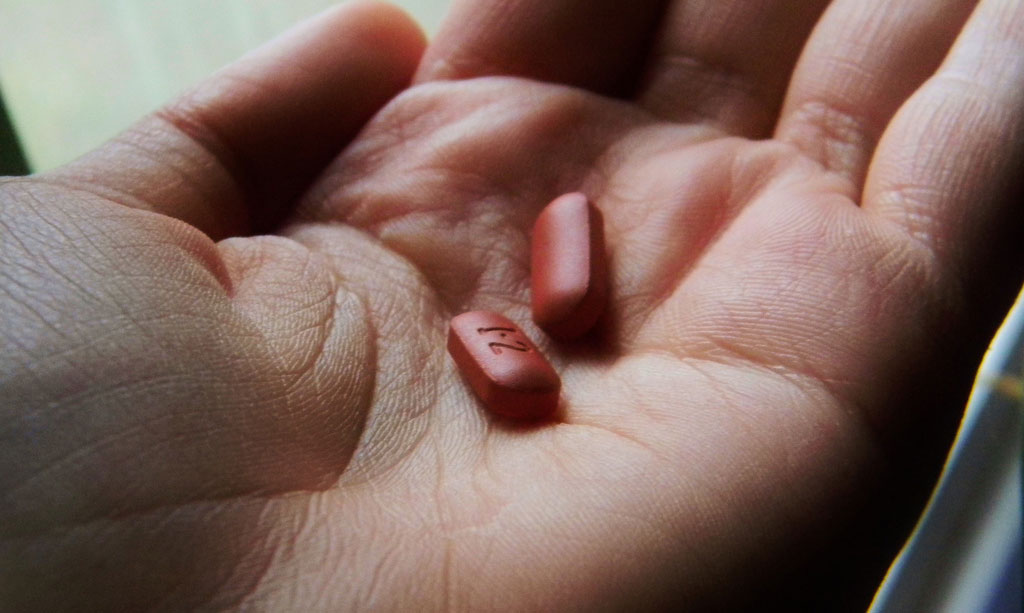 Pills in a hand, responding to illness