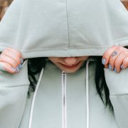 A sad woman covered her face with her hoody jacket