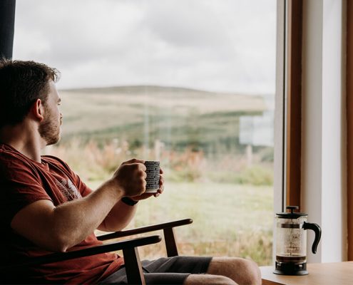 Image of a guy relaxing in front of a window