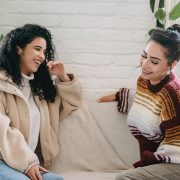 two woman is chatting on a couch